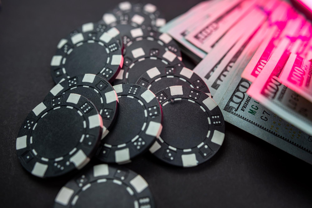 Poker chips and dollar bills on casino table